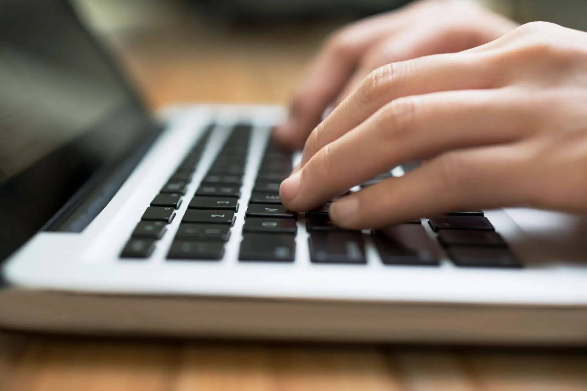 hands typing on a laptop